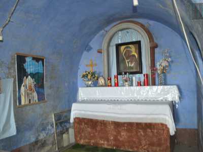 ...che sfocia davanti a un piccolo altare con il ritratto della Vergine e attorniato da mura dipinte di azzurro